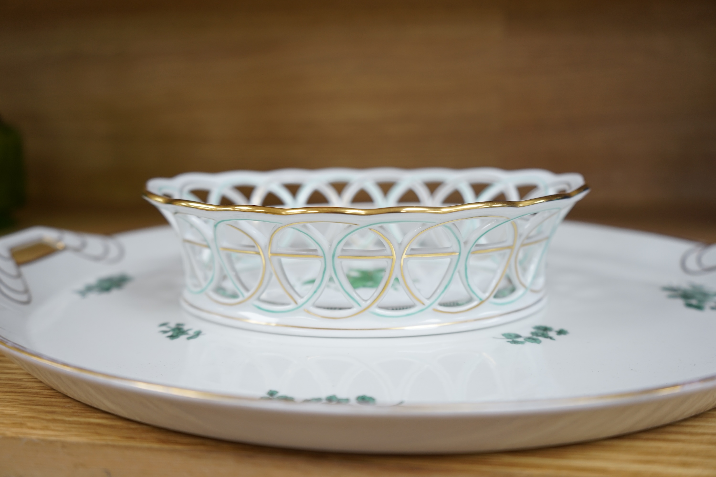 A Herend green decorated tray, 26cm wide, a similar pair of dishes and a basket, together with another larger porcelain tray, 39cm wide (5). Condition - good.